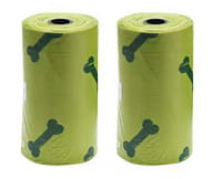 two rolls of lime green dog waste bags with black bone patterns accompanying a cat litter scoop with integrated bag dispenser for convenient pet waste management.