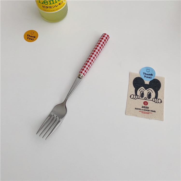 A red and white checkered stainless steel fork with a sturdy blade from the checkered stainless steel cutlery tableware set.