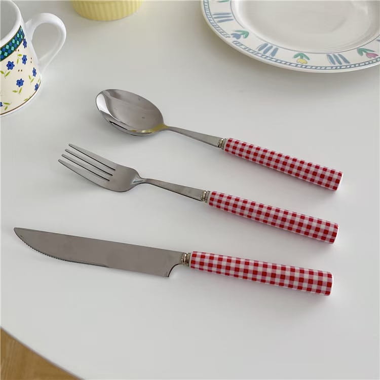 Red and white checkered handle stainless steel cutlery set with blades designed for tableware use.