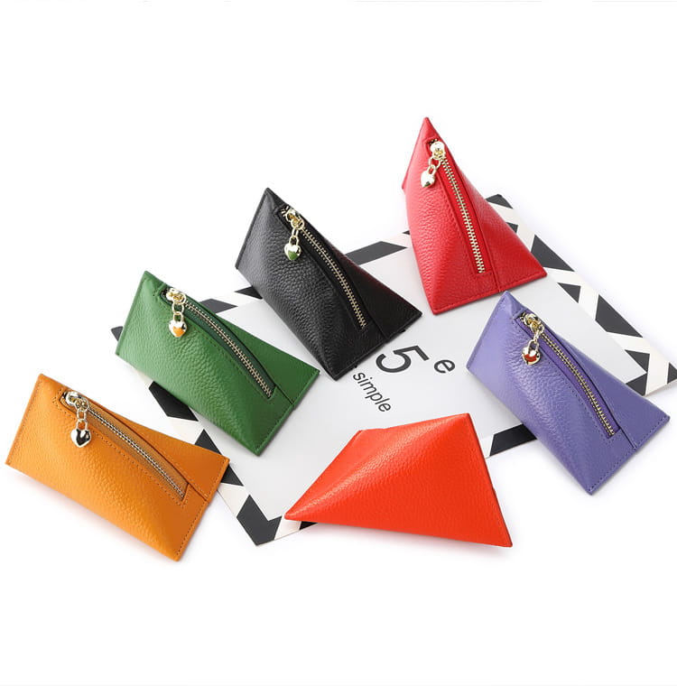 A collection of genuine leather heart charm mini coin purses in vibrant orange green black red and purple featuring triangular shapes and gold zippers with heart charms.