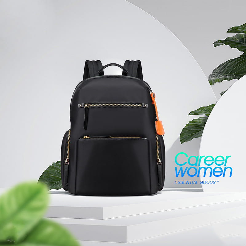 Black nylon women’s business backpack with gold-tone zippers and an orange pull tab on the side.