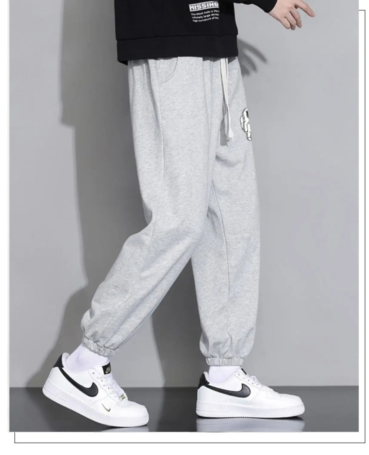Men astronaut graphic joggers casual pants in gray heathered fabric with a drawstring waist and embroidered logo on the thigh.