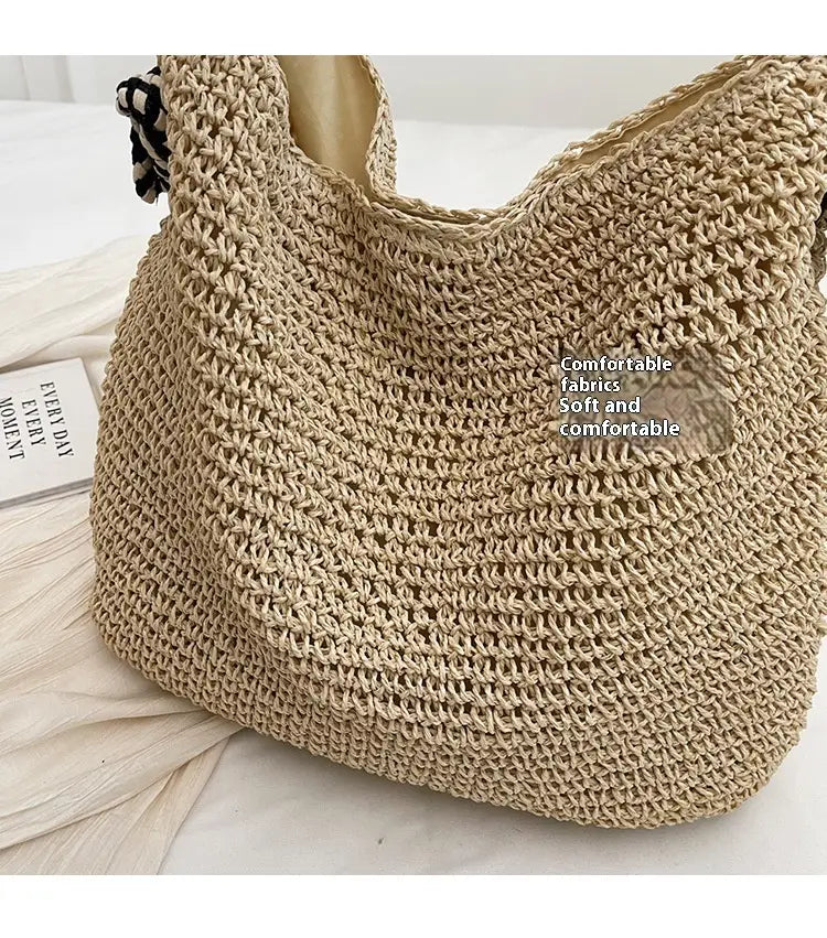 beige crocheted straw tote bag with black and white striped fabric bow handles for stylish carrying