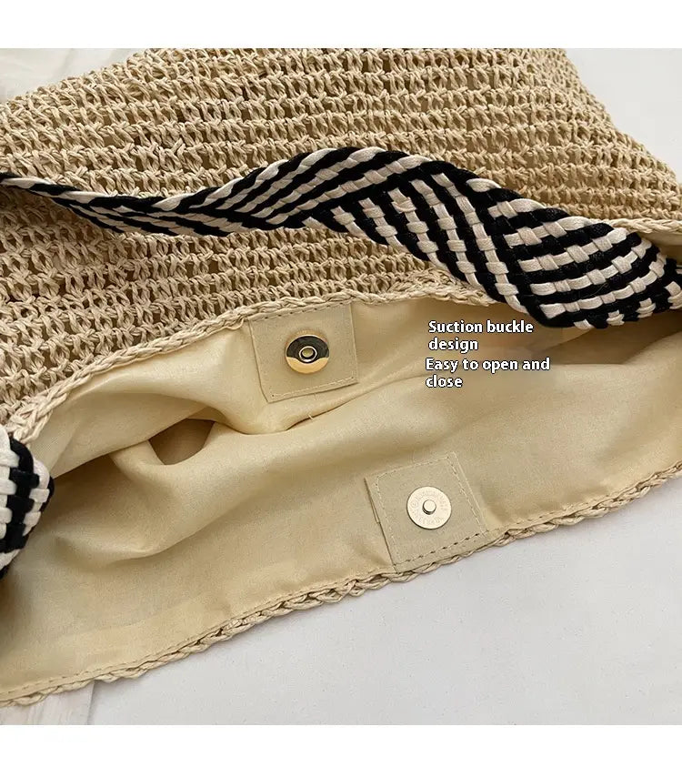 Beige woven straw tote bag with black and white striped fabric lining and bow handles for stylish carrying.