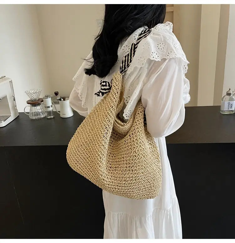 Beige woven straw tote bag with a soft textured crochet pattern and a single shoulder strap featuring striped bow handles.