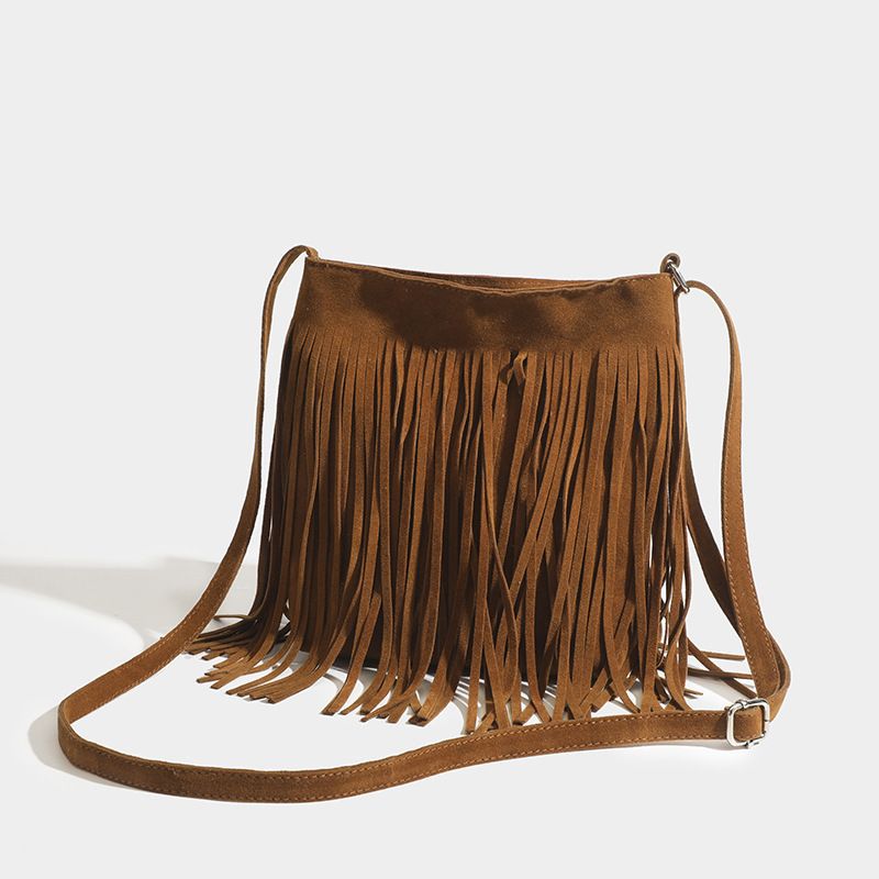 A maroon suede fringe crossbody bag with a long adjustable strap for artistic tassel canvas shoulder bag travel use.