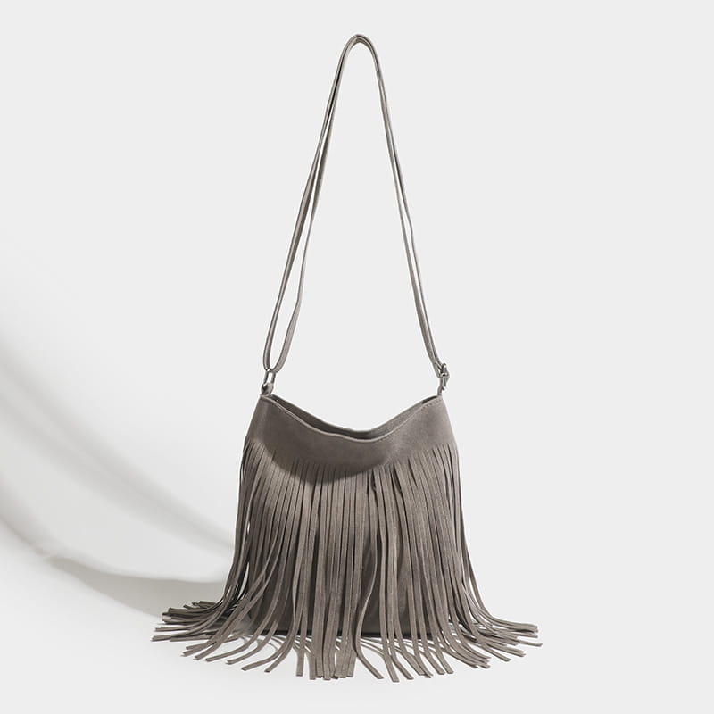 A maroon suede fringe crossbody bag with a long adjustable strap for artistic tassel canvas shoulder bag travel use.
