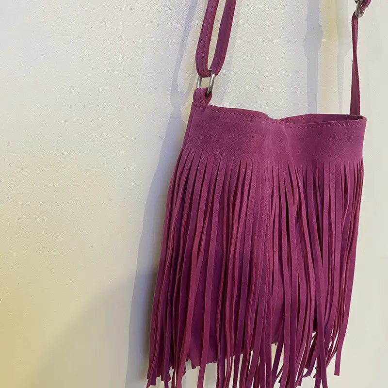 A maroon suede fringe crossbody bag with a long adjustable strap for artistic tassel canvas shoulder bag travel use.