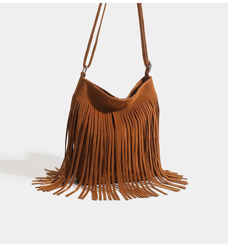 A maroon suede fringe crossbody bag with a long adjustable strap for artistic tassel canvas shoulder bag travel use.