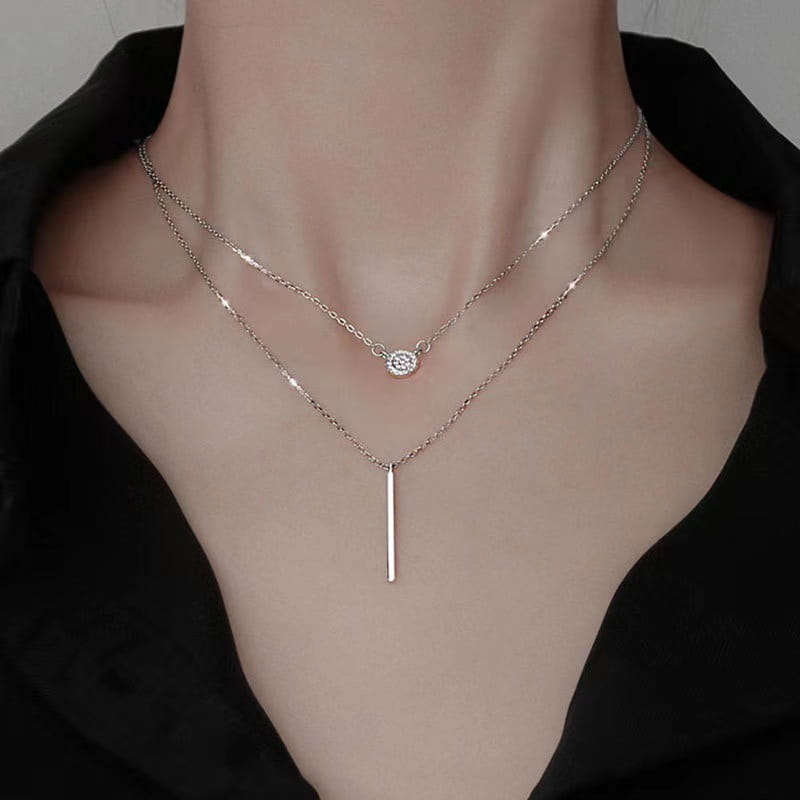 Double layer silver pave zircon round and bar pendant necklace featuring a delicate rose gold layered design with a small round diamond pendant on the top chain and a sleek vertical bar charm on the bottom.