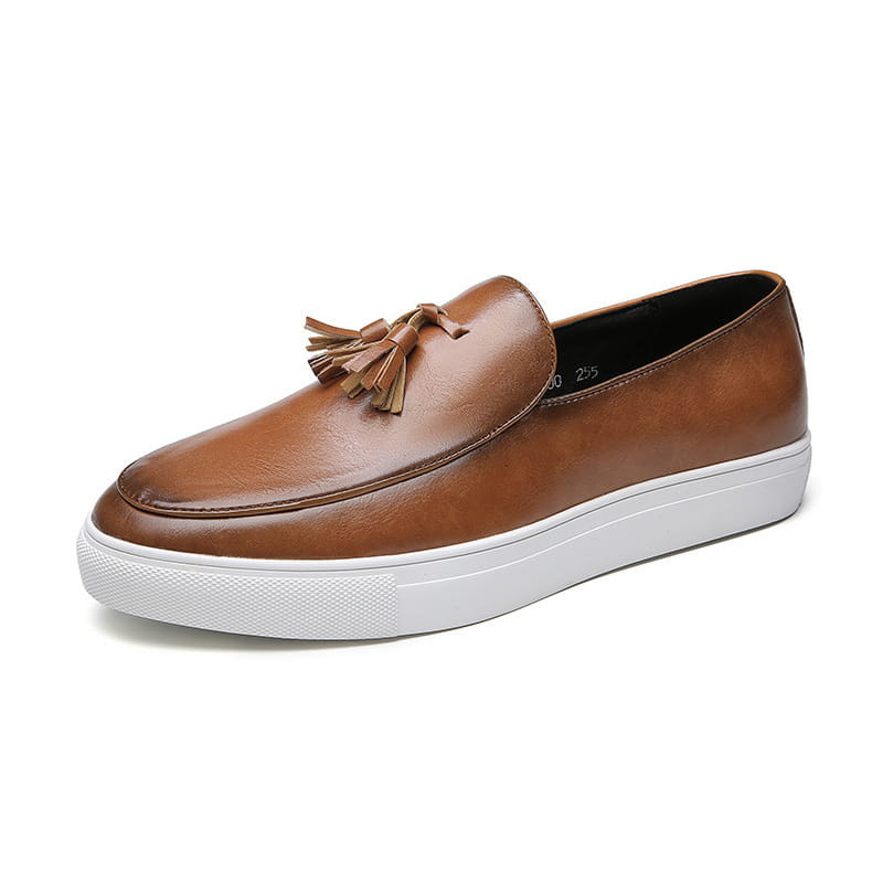 Mocassin à glands en cuir brun pour homme avec une semelle en caoutchouc blanc, présenté sous l’angle avant
