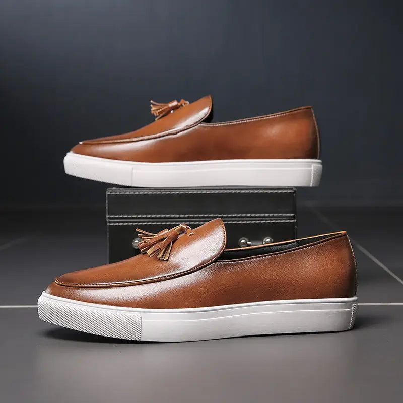 Mocassins à glands en cuir brun pour homme avec des semelles en caoutchouc blanc, présentés depuis l’arrière.
