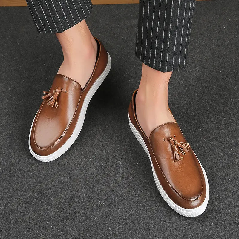 Mocassins à glands en cuir brun pour homme avec des semelles en caoutchouc blanc, présentés depuis l’arrière