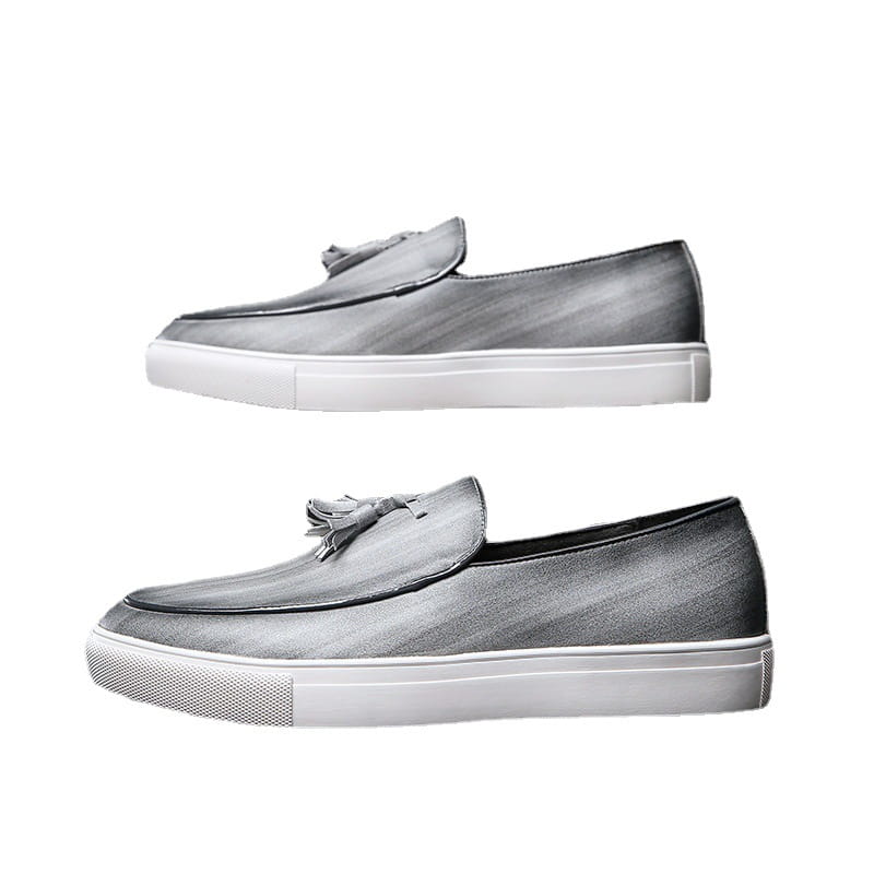 Mocassins à glands en cuir gris pour homme avec semelles en caoutchouc blanc et détails à glands.