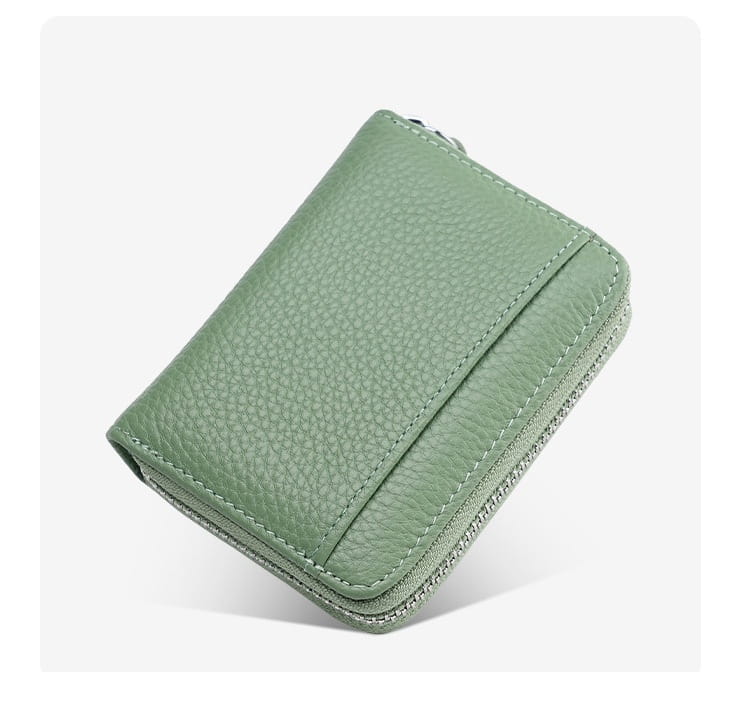 A compact sage green rfid leather card wallet with a zipper coin pocket and matching stitching made of pebbled leather.