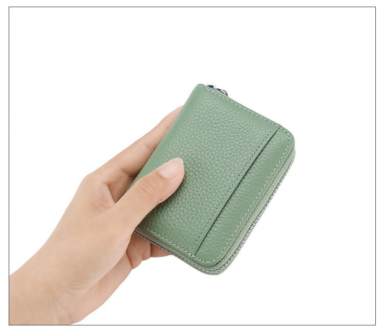 A compact sage green pebbled leather rfid card wallet with a zipper coin pocket and stitched edges.