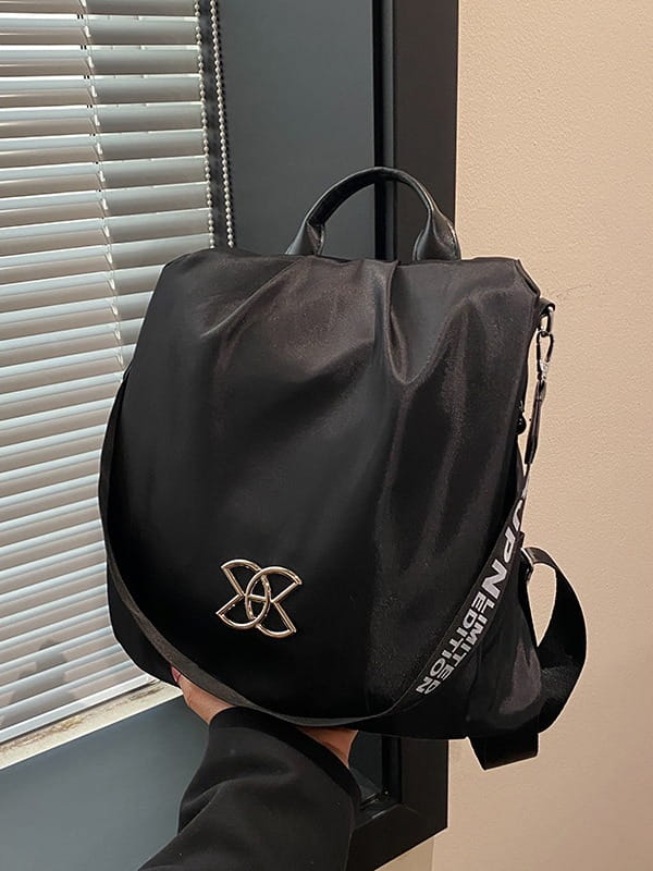 Black nylon waterproof large capacity travel backpack with pu leather trim silver metallic logo and adjustable strap with white lettering shown from the back side.