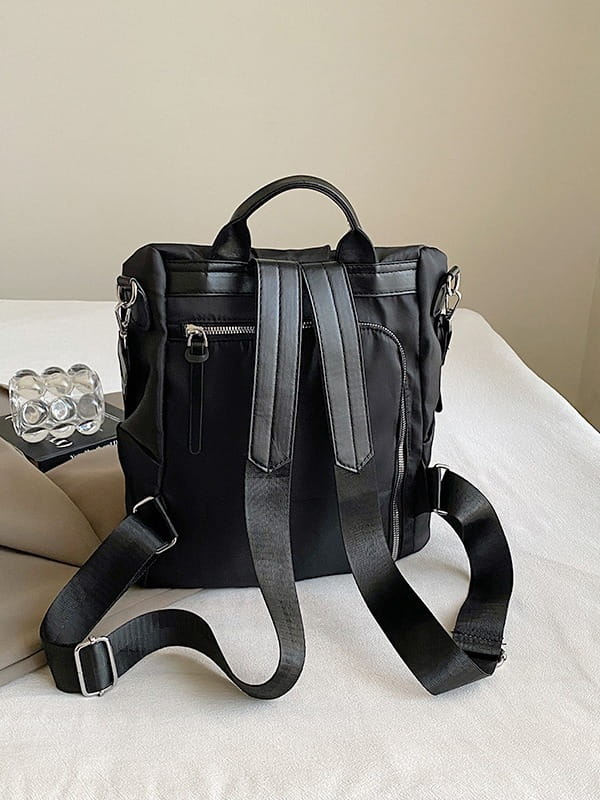 Black nylon backpack with pu leather trim and adjustable straps shown from the back side, designed for waterproof large capacity travel use.
