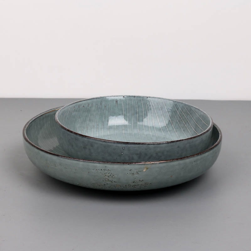 Set of two matte sage green ceramic bowls with subtle vertical ridges and rustic speckled glaze from the ceramic dinnerware set retro ribbed plates and bowls.