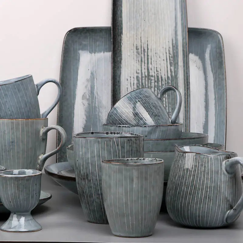 Gray ceramic dinnerware set featuring retro ribbed plates and bowls with a vertical ribbed texture and rustic handcrafted finish.