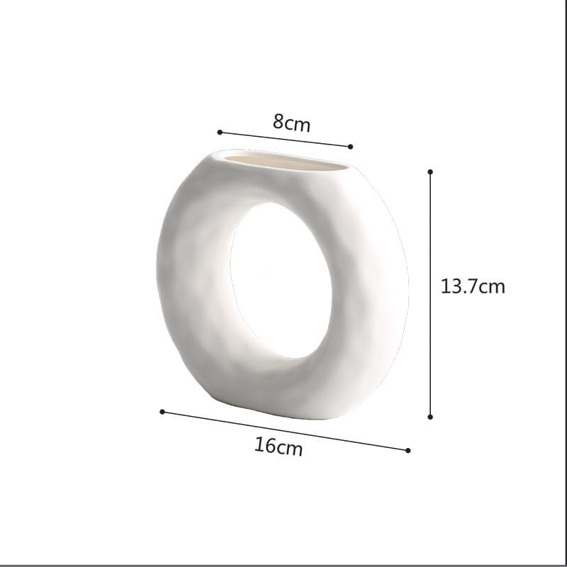 White ceramic ring-shaped vase with a smooth matte finish and rounded edges in a minimalist Scandinavian textured pottery style.
