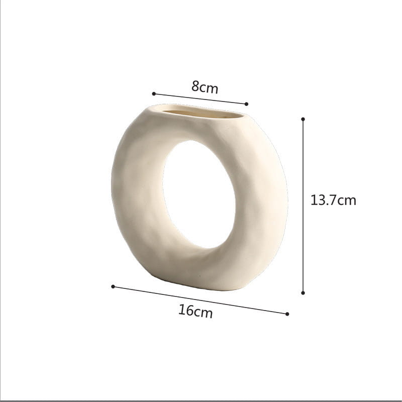 Cream-colored ceramic vase with a smooth rounded ring design and subtle texture embodying minimalist Scandinavian textured pottery.