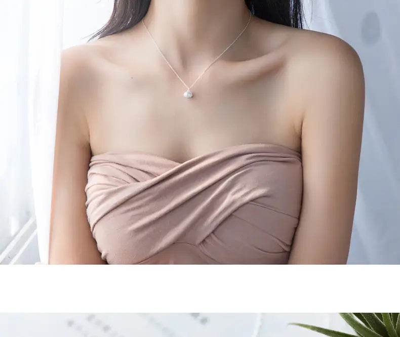 A delicate silver necklace featuring a small round pearl pendant made of personalized S925 silver shell and pearl.