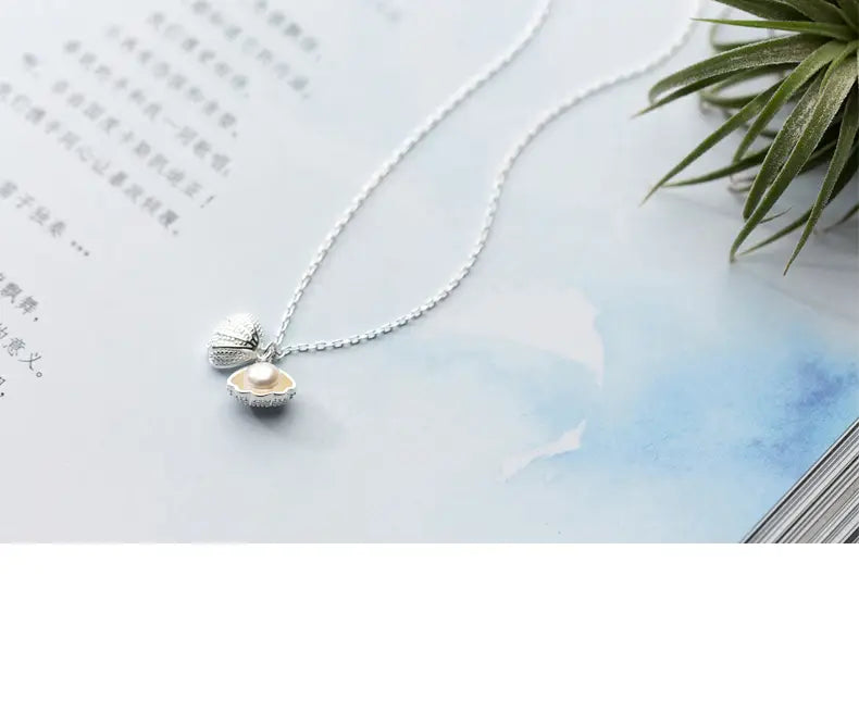 personalized s925 silver shell and pearl pendant necklace featuring a silver open clamshell design with a pearl nestled inside.