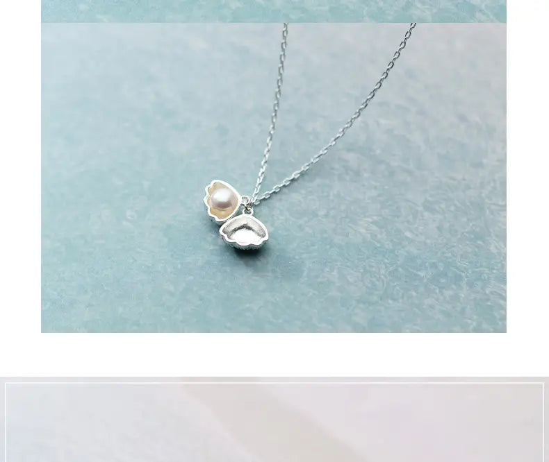 silver s925 shell and pearl pendant necklace featuring a delicate chain and a single pearl nestled inside an open silver seashell