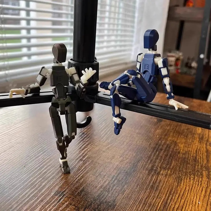 黒色のトライポッドアーム上にポーズを取らせた、濃いグレーと青色の白色関節付き、2体の3Dプリント関節可動ロボットアクションフィギュア用ダミー 2.0。