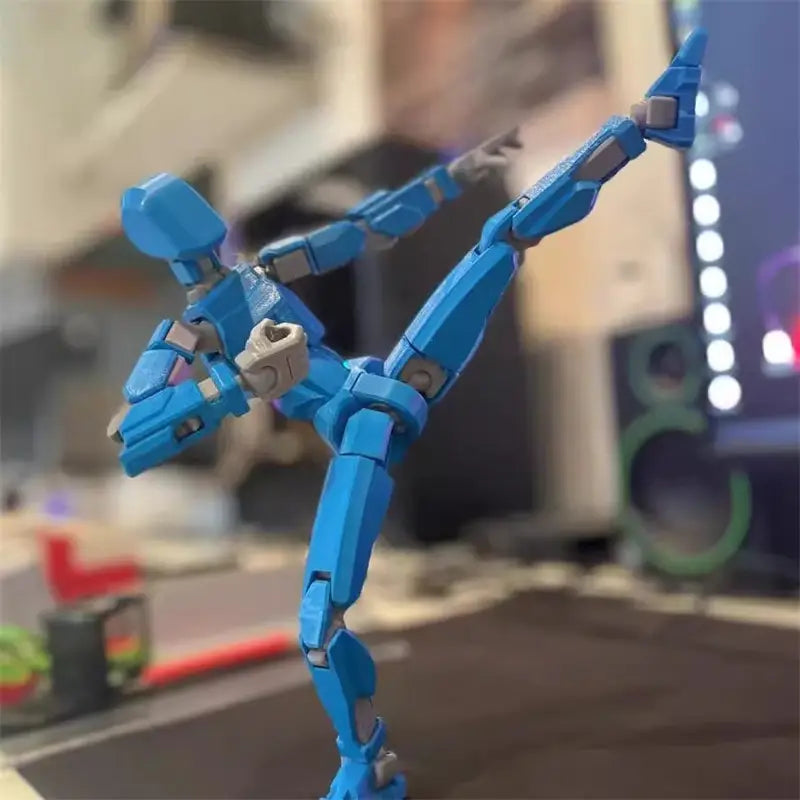 ダイナミックなミッドキックのポーズで、グレーの関節を備えた青色の3Dプリント関節可動ロボットアクションフィギュア用ダミー 2.0。