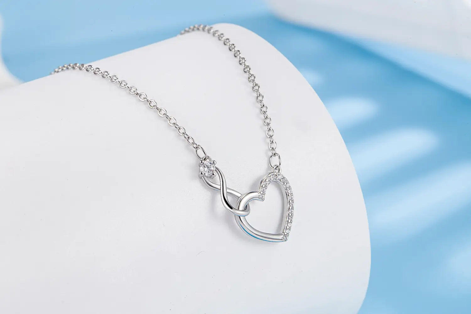 Silver infinity heart pendant necklace with pave-set diamonds on a delicate 925 sterling silver chain.