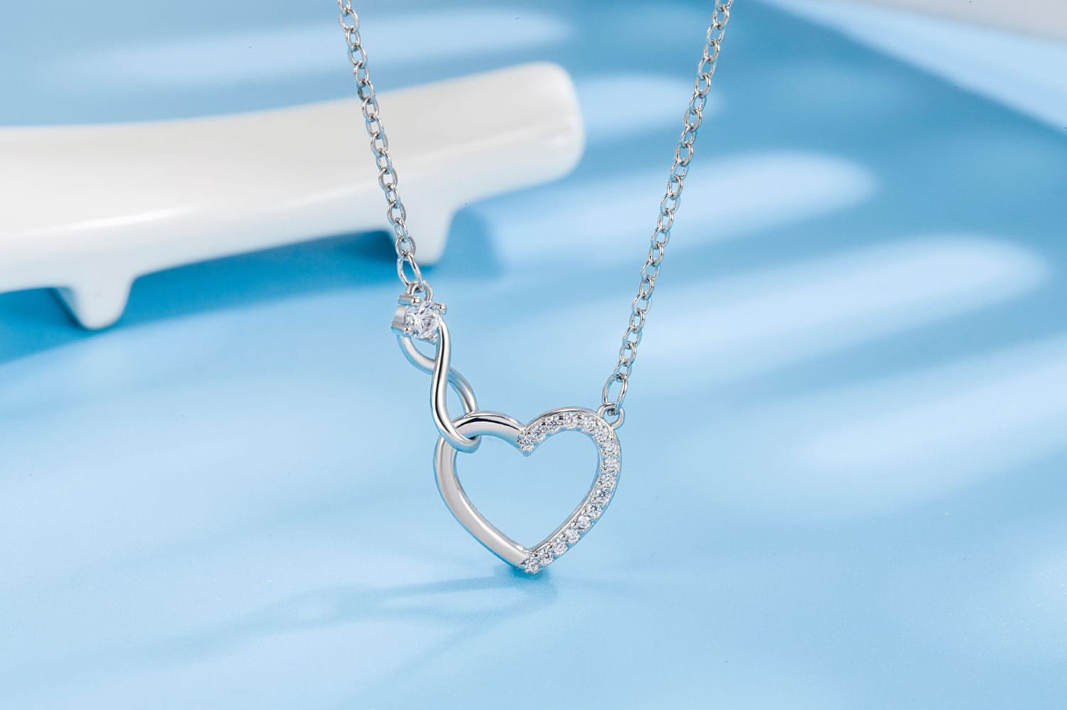 Silver 925 sterling silver pave crystal infinity heart necklace with sparkling diamonds along the outline and a small diamond accent at the top.