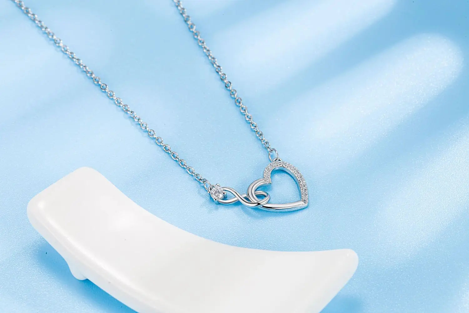 Silver 925 sterling silver pave crystal necklace featuring an infinity symbol intertwined with a heart adorned with sparkling diamonds along the edges.