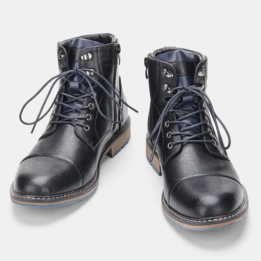 Botas de invierno de cuero para hombre con cuero negro, detalles en azul marino, puntera tipo cap y ojales plateados con diseño de cordones.