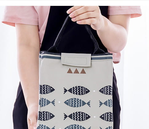 Mini cartoon oxford insulated picnic handbag in yellow with navy fish and white wave pattern featuring black handles.