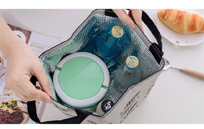 Mini cartoon oxford insulated picnic handbag in yellow with navy fish and white wave pattern featuring black handles.