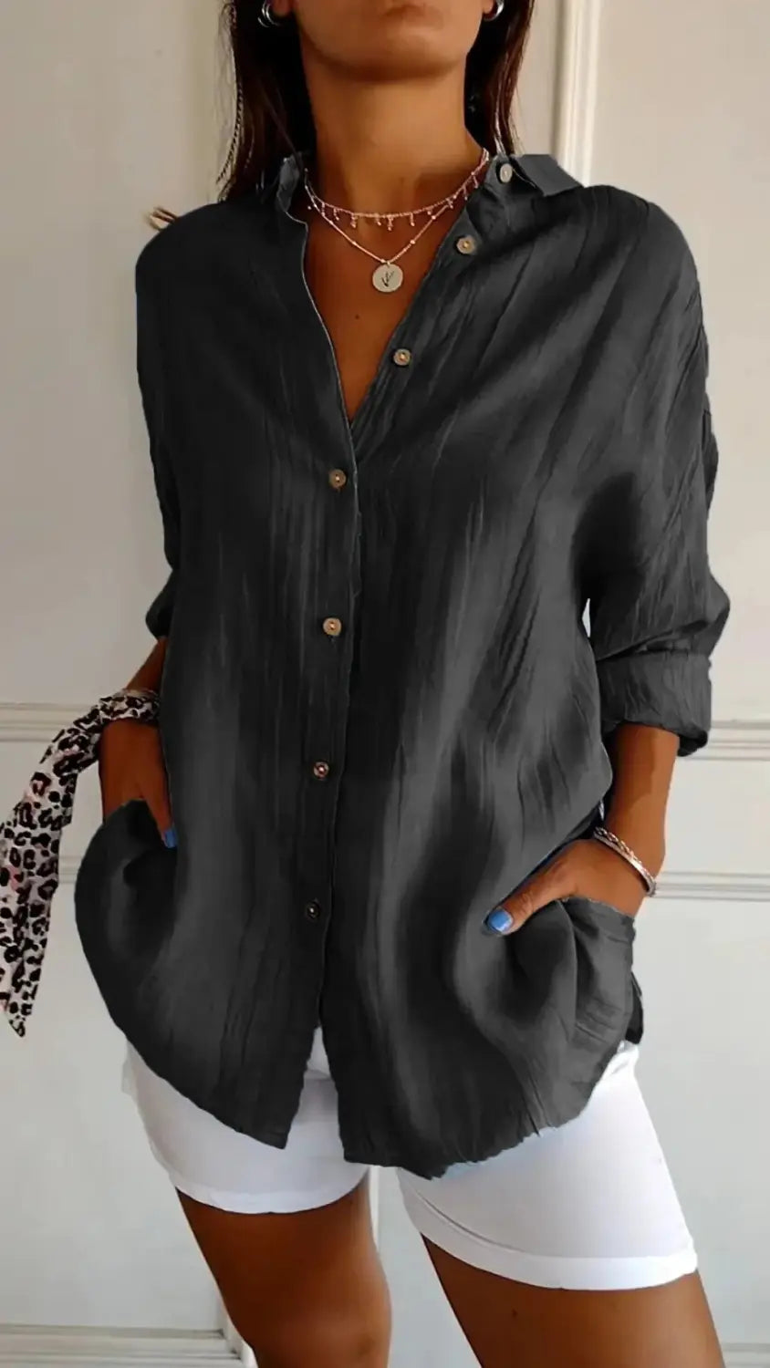 Black relaxed fit button-up shirt for women with pleated front and rolled sleeves.
