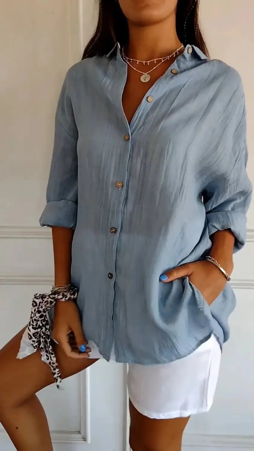 Light blue linen women’s relaxed pleated button up shirt with rolled sleeves and a relaxed fit.