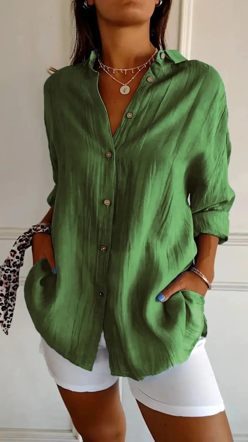 Green relaxed fit pleated button up shirt for women with rolled sleeves.
