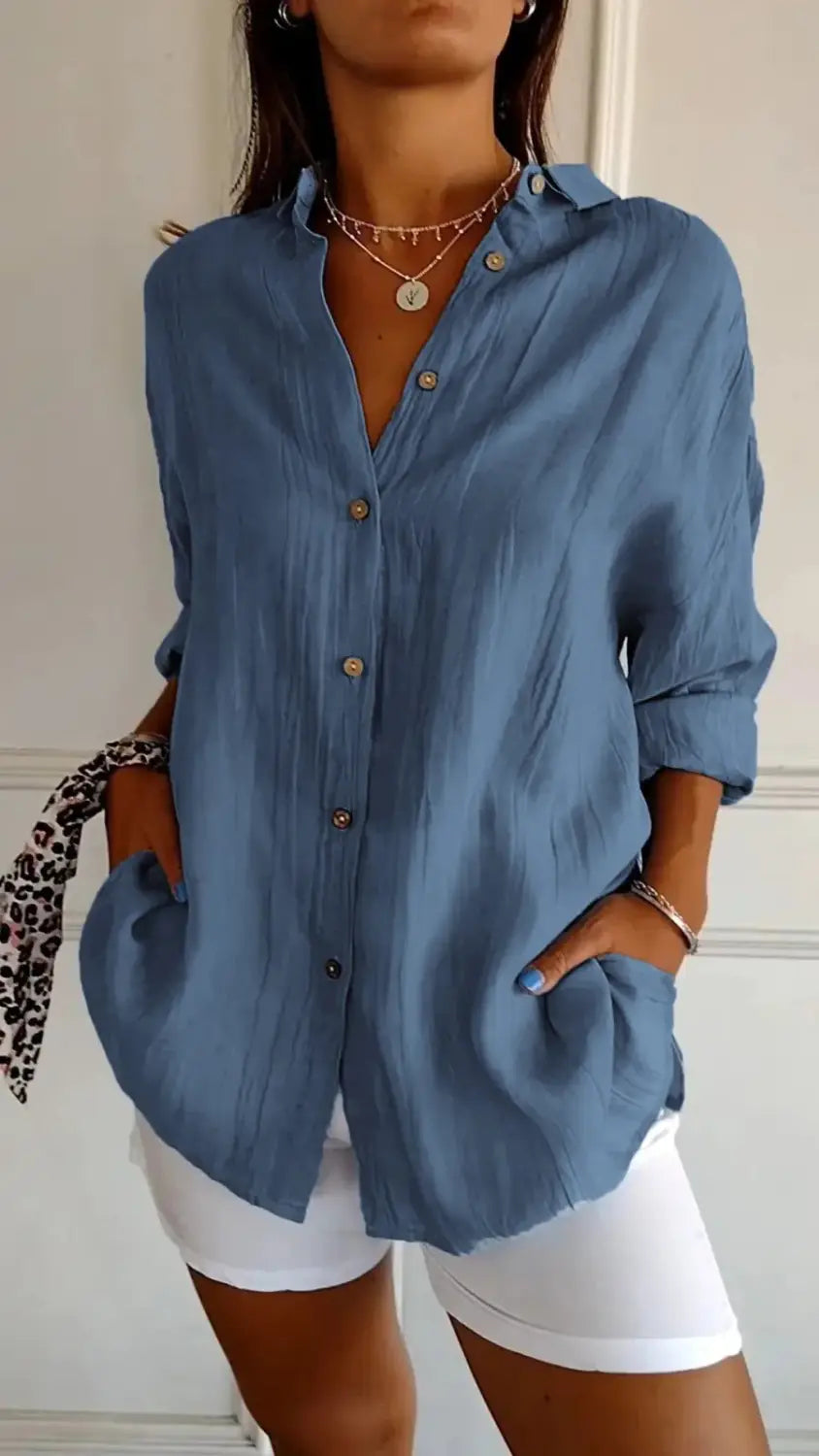 women’s relaxed pleated button up shirt in soft light blue with a relaxed fit and rolled sleeves made from lightweight material.