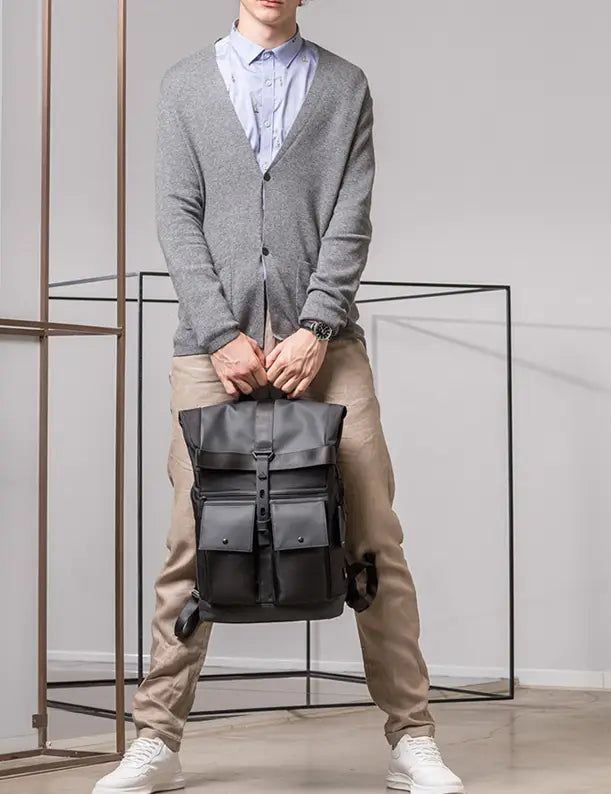 Men’s 16 inch roll top laptop backpack in black waterproof nylon with multiple front pockets and adjustable shoulder straps