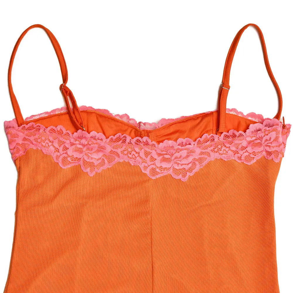 Ein orangefarbenes Spaghetti-Träger-Camisole mit rosafarbenem floralem Spitzeinsatz als Teil eines Midikleids aus orangefarbenem Spitzeinfasstungs-Mesh.