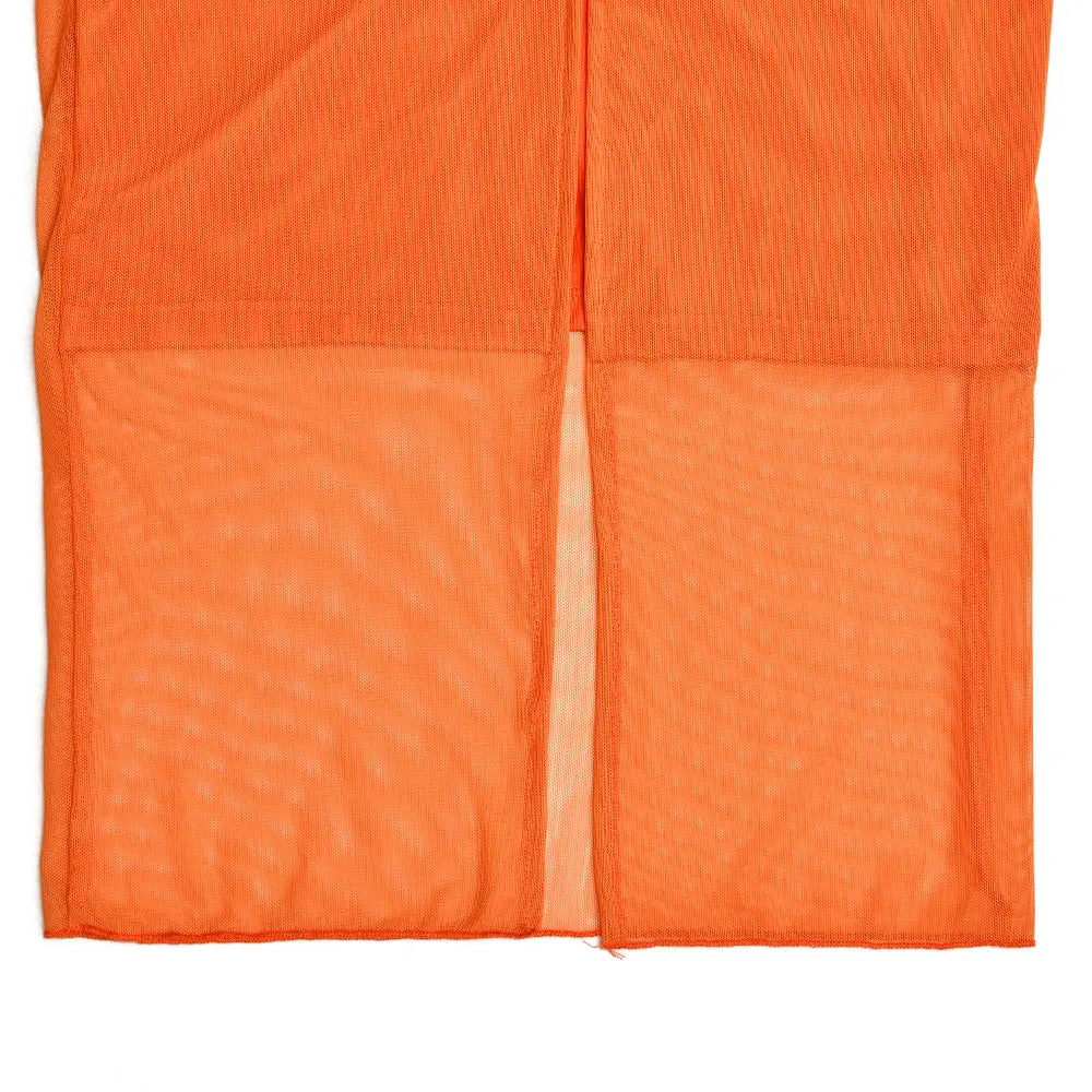 Helle orangefarbene Cord-Hosen mit einem transparenten Mesh-Panel im unteren Vorderbereich, passend zum Midikleid aus orangefarbenem Spitzeinfasstungs-Mesh.