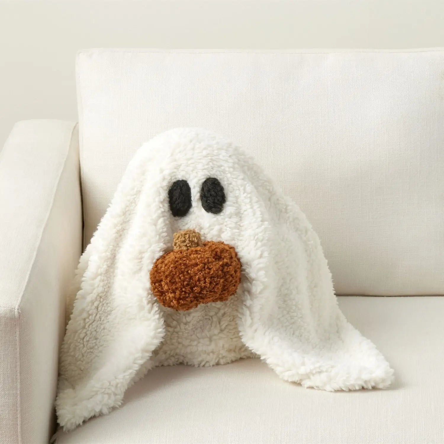 Gus, der Geistkürbis-Halloween-Plüschkissen-Spielzeug, ist eine weiße Plüschdecke in Form eines Geistes mit schwarzen bestickten Augen und einer braun gehäkelten Kürbisnase.