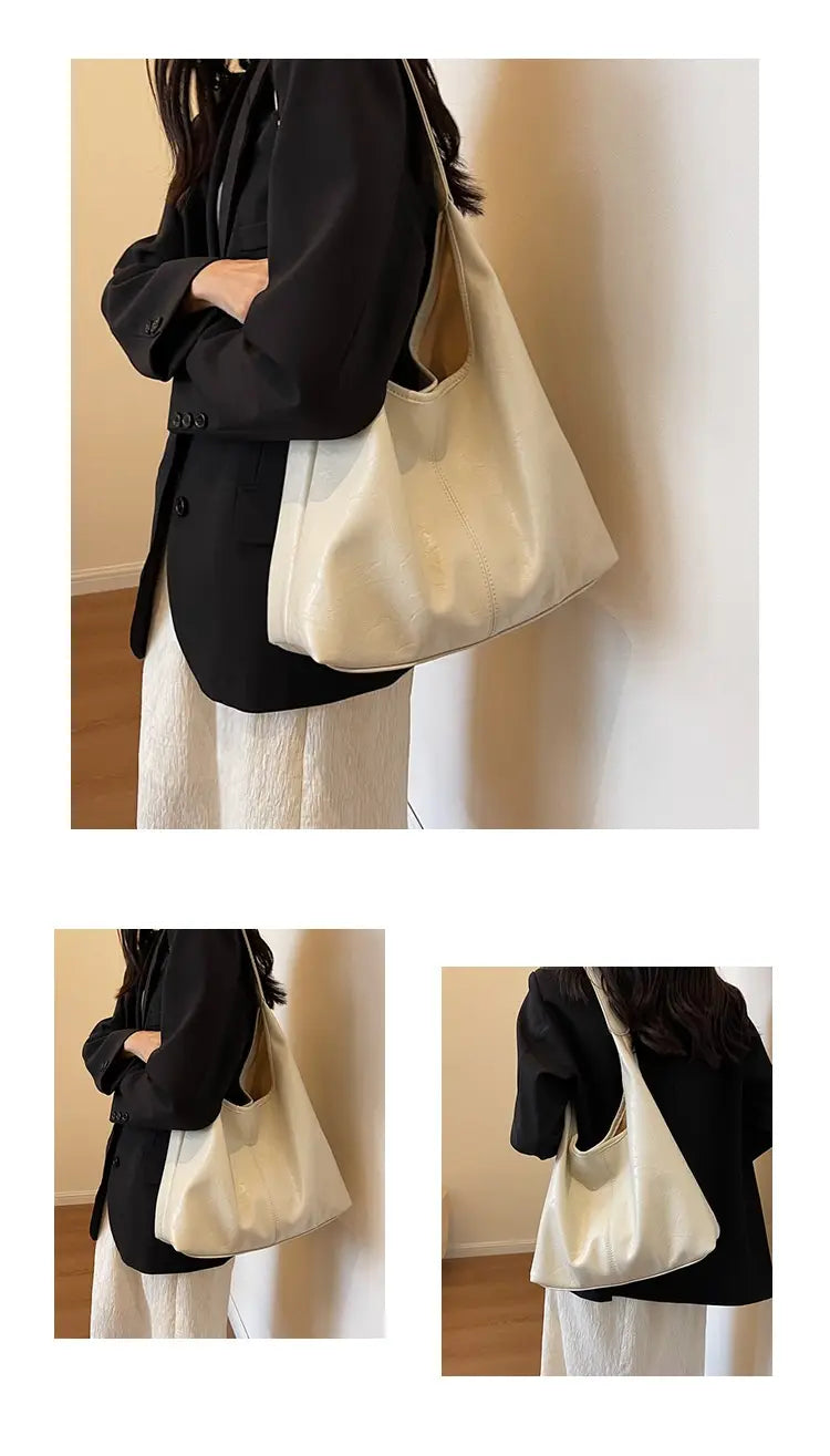 Vintage-Leder-Tragetasche mit cremefarbener weicher Struktur, minimalistischem Design und einem einzelnen Schulterriemen für die Nutzung mit großer Kapazität.