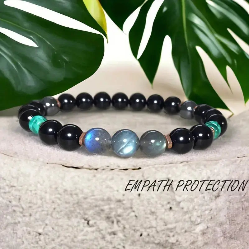 Natural amethyst and magnetic stone beaded unisex bracelet featuring alternating black obsidian, teal aventurine, and iridescent labradorite stones separated by copper-toned spacers.