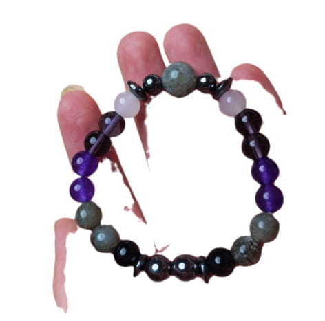 A natural amethyst and magnetic stone beaded unisex bracelet featuring alternating round purple gray and black stones with smooth and faceted finishes.