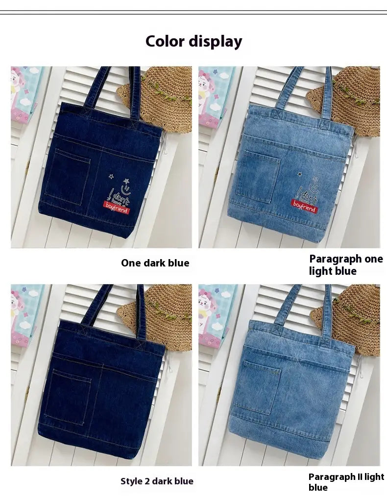 Embroidered denim tote bag with a smiley face and boyfriend patch in various blue shades featuring a soft handle.