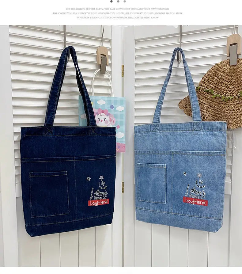 Embroidered denim tote bag with slogan i don’t have a boyfriend in white and red thread featuring one large pocket and a soft handle.